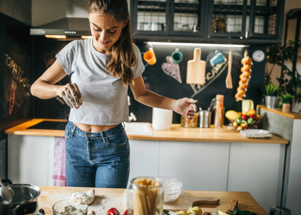 istock Young woman making pizza at home 1049040246