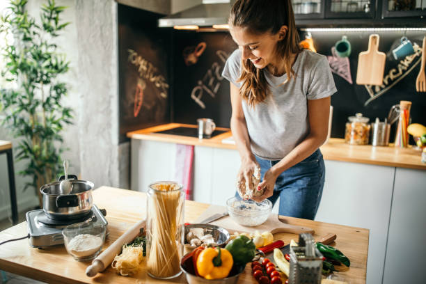 jeune femme préparant une pizza - préparation des aliments photos et images de collection