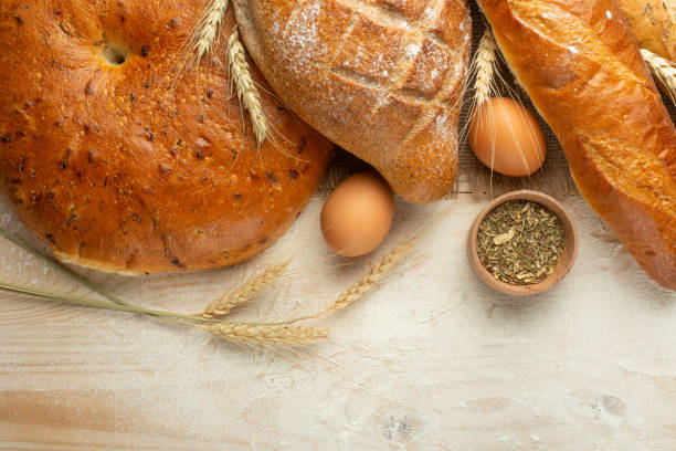 istock Fresh bread on a wooden table with flour and wheat, eggs and empty space. Concept baking, bakery 1049042998