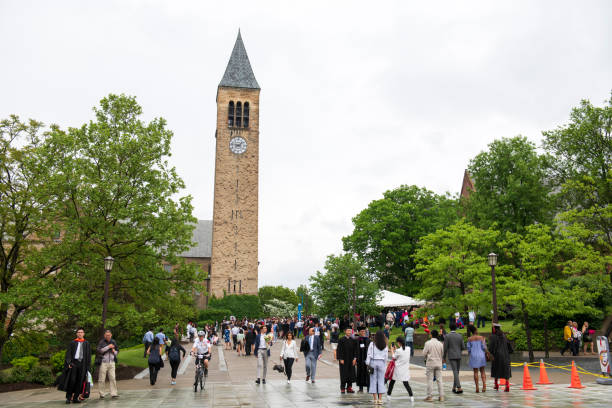 students and their family members gathered by jennie mcgraw tower in the campus of cornell university on commencement day - mcgraw imagens e fotografias de stock