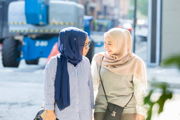 istock Two Malaysian sisters walk home together from work 1049050938