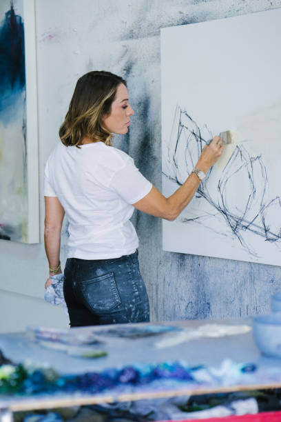 istock Woman painting canvas in art studio 1049053684