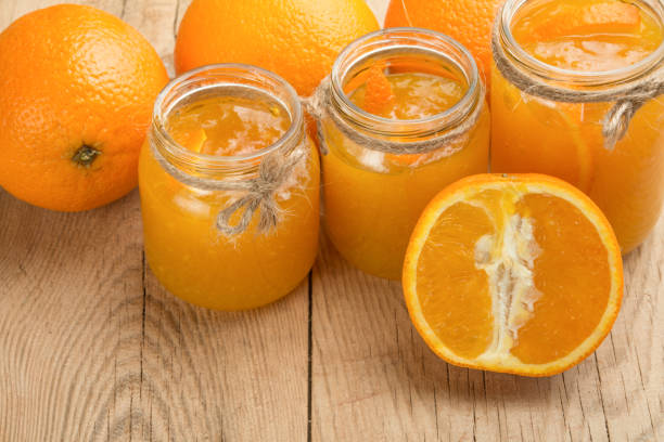 istock Orange jam in a glass jar on a wooden background. 1049057694