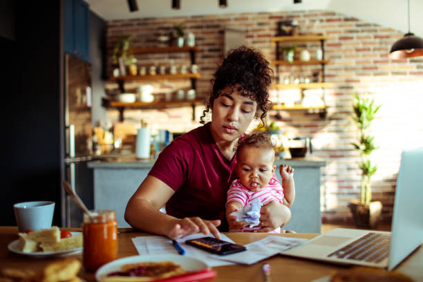 Mother and Daughter Close up of a mother using a phone with her daughter while having breakfast and doing bills pancake photos stock pictures, royalty-free photos & images