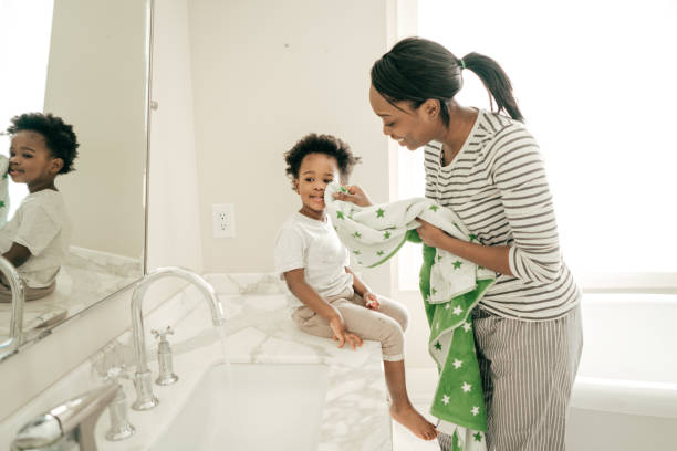 hygiene und gesundheit - mirror mother bathroom daughter stock-fotos und bilder