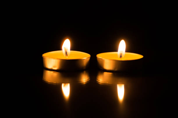 istock Two candles in the dark with reflection 1049068674
