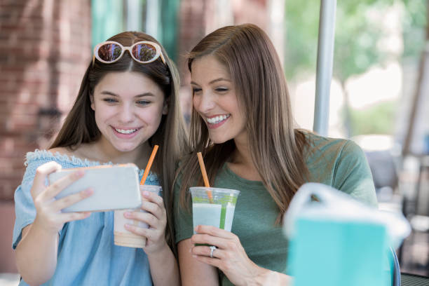 felice madre e figlia adolescente che si fanno selfie mentre bevono frullati - blueberry smoothie milk shake drink foto e immagini stock