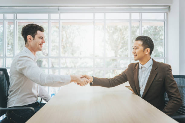istock businessmen shaking hands in an office 1049076862
