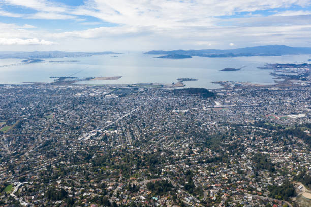 San Francisco Bay Aerial The San Francisco Bay Area has a complex network of infrastructure that supports one of the most populous areas on the west coast of the United States. This urban area is home to 7.6 million people. san francisco county city california urban scene stock pictures, royalty-free photos & images