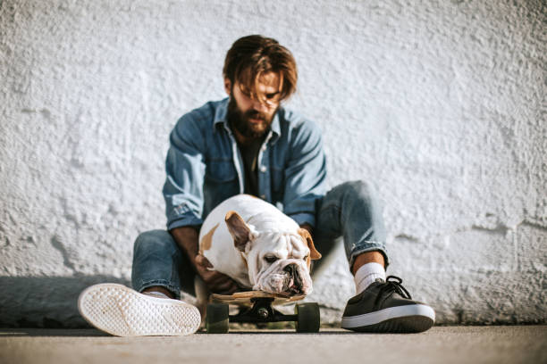 istock Skater Having a Break With His Dog, Training Him To Ride Skateboard 1049084166