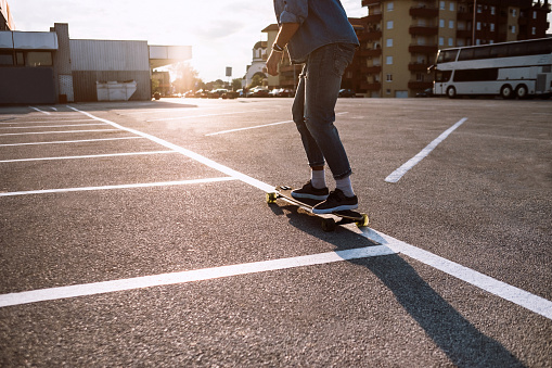 Young Man Skating On Parking While Moving Lively To Dawn And Sunset of Sunny Summer Day