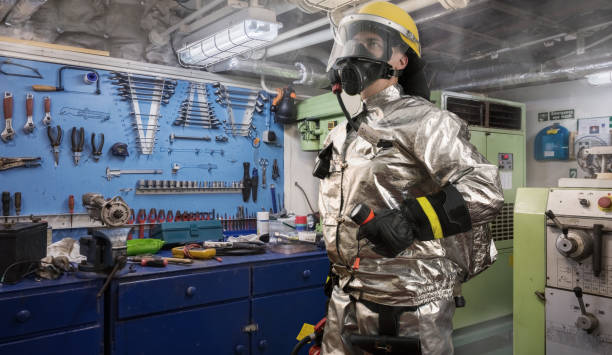 istock Brave fireman exploring a fire scene onboard of a ship with torch and fire extinguisher in hands. All area around covered with smoke. 1049084452