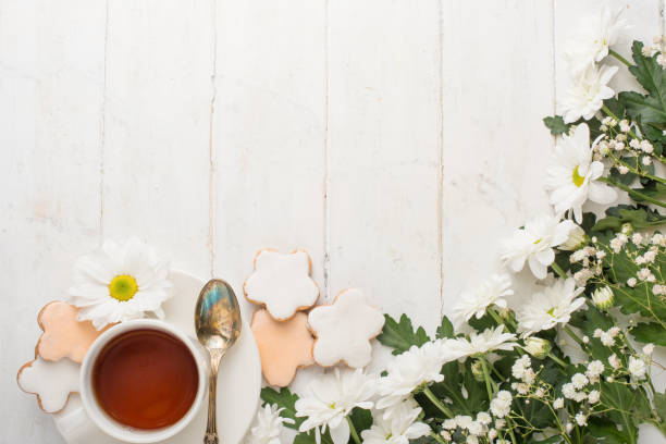 istock Flowers, biscuits and tea. On a light texture, a top view with an empty space for an inscription 1049086922