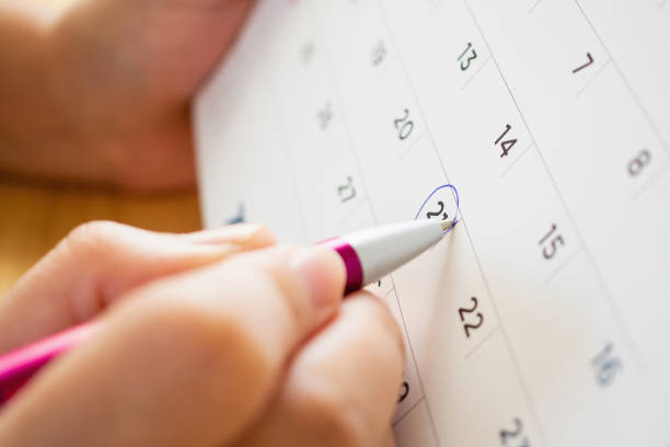 istock calendar page with female hand holding pen 1049089544