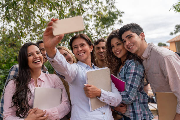 istock Happy teacher with a group of students taking a selfie 1049099170
