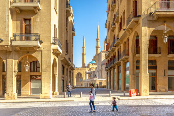 Young mother and a kid walking in the old town of Beirut, mosque in the background, blue sky, Beirut, Lebanon Young mother and a kid walking in the old town of Beirut, mosque in the background, blue sky, Beirut, Lebanon lebanon beirut stock pictures, royalty-free photos & images