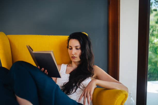 istock Young woman relaxing and reading a book 1049102062