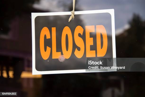 Closed Sign Hanging In Business Window By A String Crooked With Glob Of Glue Also Attaching It To Window Some Abstract Reflections Stock Photo - Download Image Now