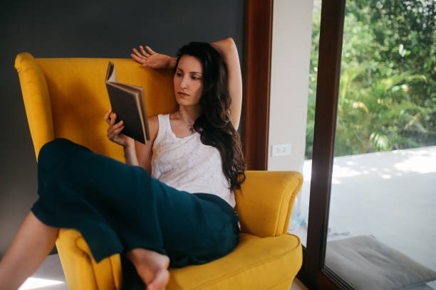 istock Young woman relaxing and reading a book 1049104330