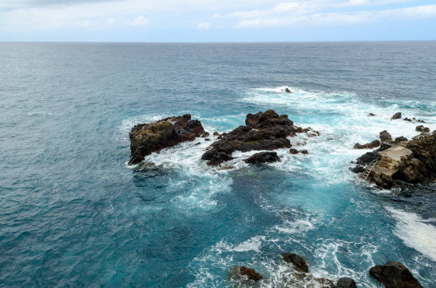 rocky coastline, natural volcanic rock, foaming water