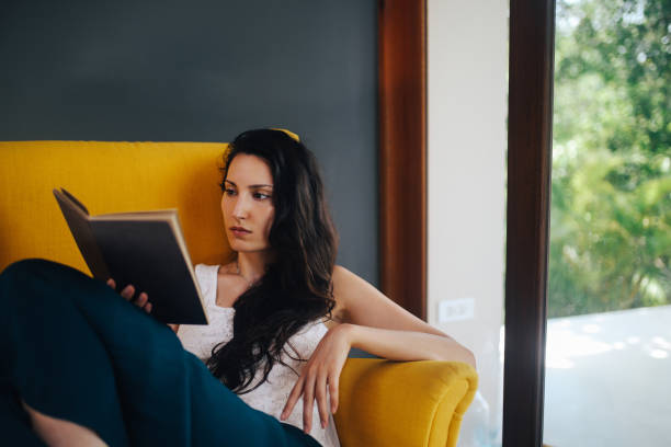 istock Young woman relaxing and reading a book 1049104962