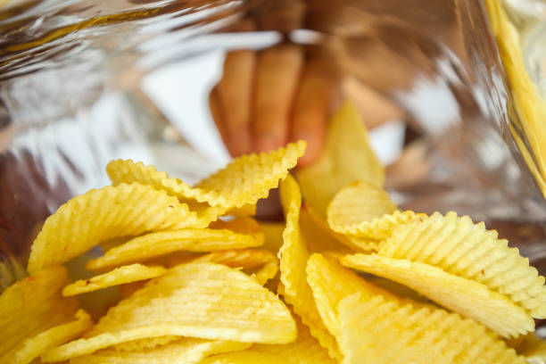 istock Hand hold potato chips inside snack foil bag 1049110050