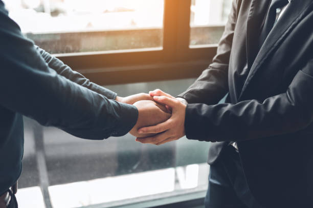 Business people compassionately holding hands at office room. stock photo