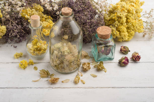 istock Medicinal herbs in glass jars on light backgrounds 1049120596