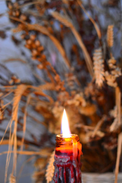 istock Candle Burning Low and Dried Wheat Background 1049123488