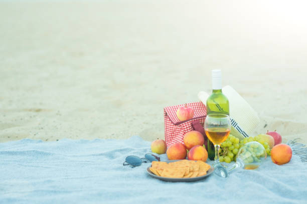 istock Picnic background with bag, grape and white wine on the beach by blue sea 1049142818