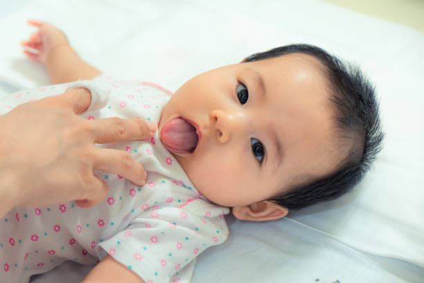 istock Mother is checking baby tongue after cleans. 1049150292