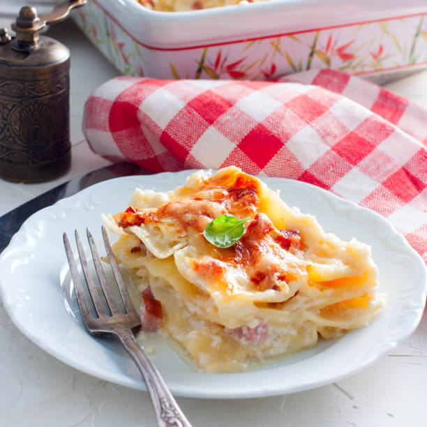 Cut a piece of lasagna with ham, selective focus