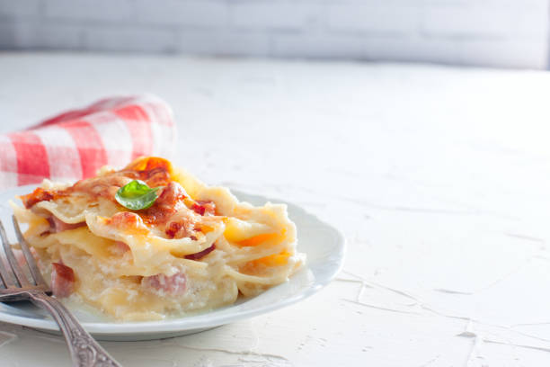 A slice of homemade lasagna with ham and cheese, copy space