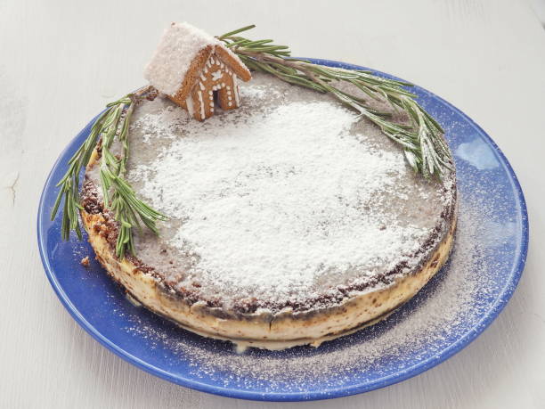 Christmas gingerbread cake decorated with small gingerbread house and rosemary stems. Traditional Christmas treat. stock photo