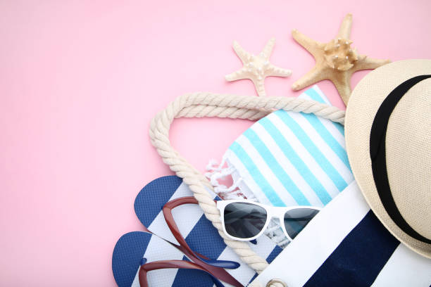 istock Summer bag with flip flops and starfishes on pink background 1049186656