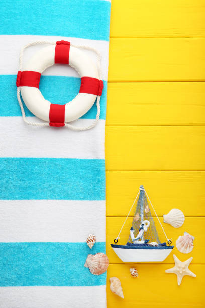 istock Summer accessories with decorative ship on yellow wooden table 1049189468