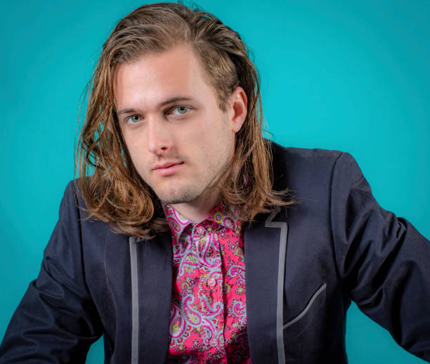 istock close up of young man pondering and looking at camera. 1049192432