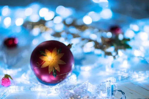 Close up of Christmas ball ornament on the table with Christmas light blur background