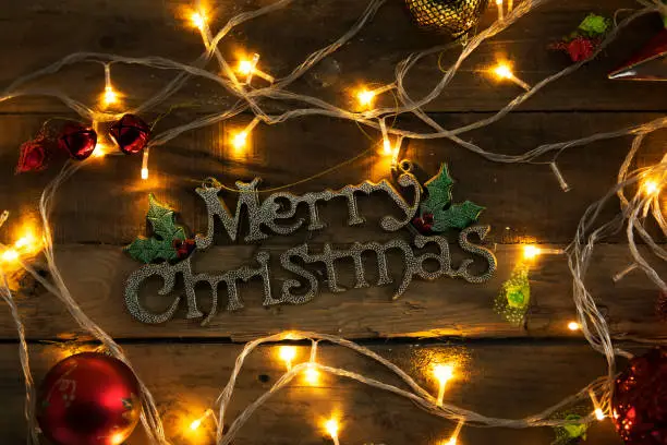 Top view of Christmas ornament with Merry Christmas text on the wooden table