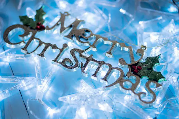 Closeup of Christmas star lights with Merry Christmas text on the wooden table