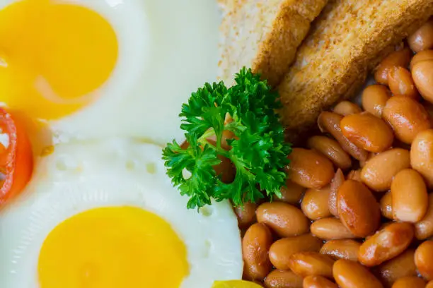 Closeup of healthy breakfast with fried egg, toast and beans on the plate