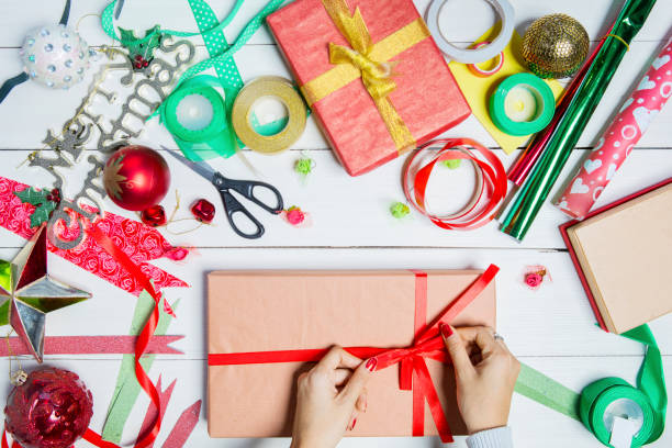 istock Woman hands decorates Christmas gift boxes 1049192666