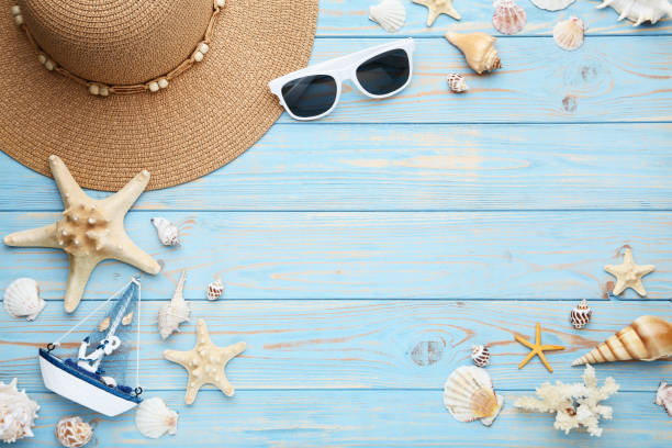 istock Different seashells with sunglasses and decorative ship on wooden table 1049195156