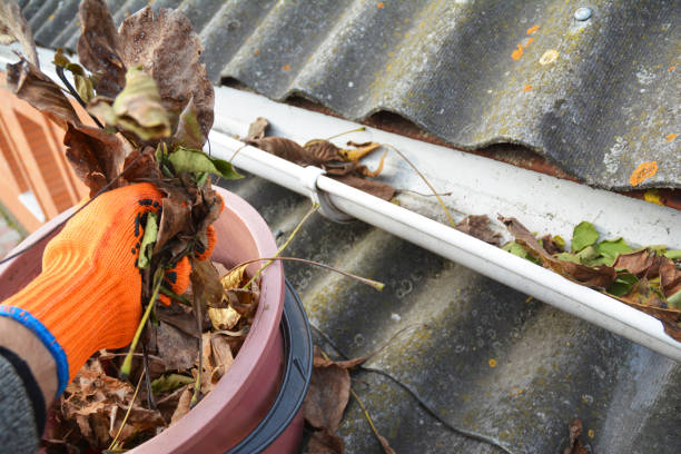 istock Rain gutters cleaning from leaves. Asbestos roof gutter cleaning. 1049201362