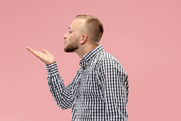 retrato de hombre atractivo con beso aislado sobre fondo rosa - blowing men kissing blowing a kiss fotografías e imágenes de stock