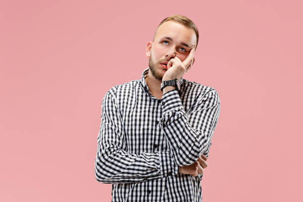 istock Beautiful bored man bored isolated on pink background 1049202066
