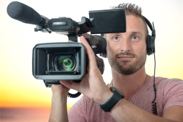 istock smiling man with professional camcorder and headphones 1049204780