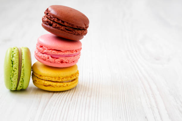 istock Colorful macarons on a white wooden background, side view. Close-up. Copy space. 1049216802