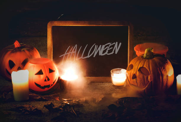istock Halloween pumpkins and candles with blackboard 1049217704