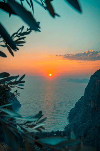 pôr do sol em kelebekler vadisi, butterfly valley, fethiye, turquia - cloud sea beach umbrella sky - fotografias e filmes do acervo